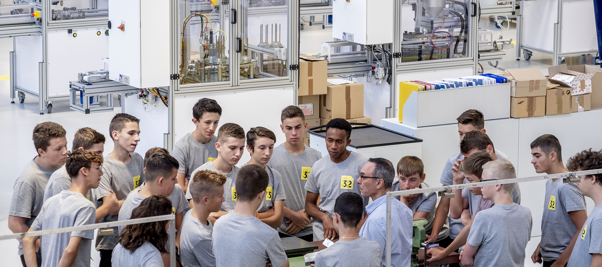 Formateur expliquant le fonctionnement d'une pièce à ses apprenants sur le plateau technique