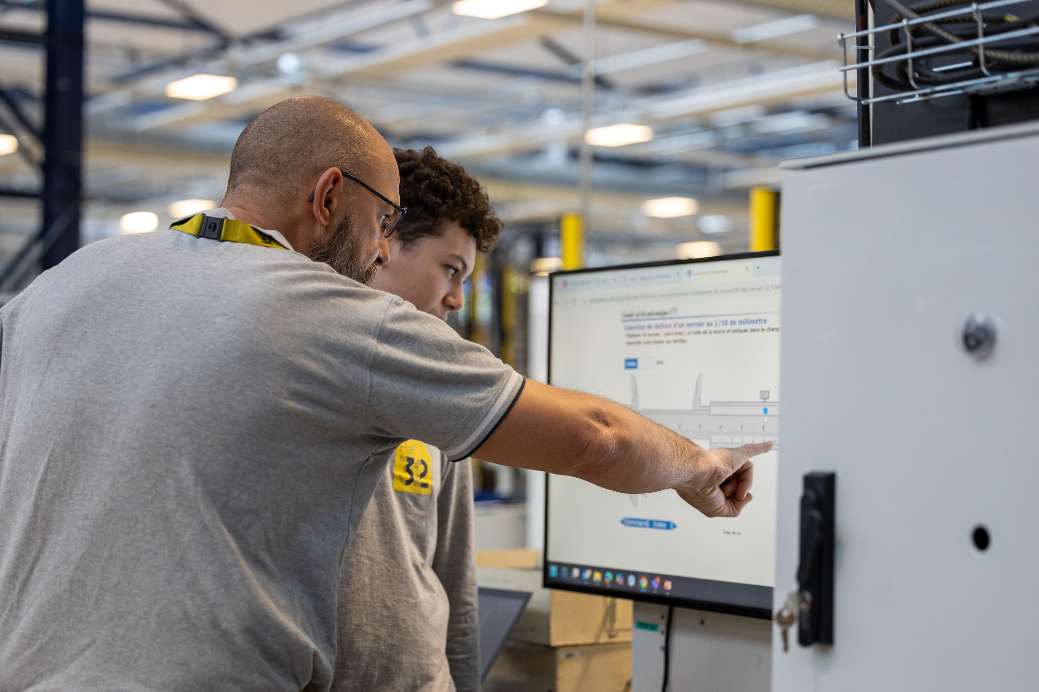 Apprenants en bac pro à hall 32 avec un formateur en mécanique